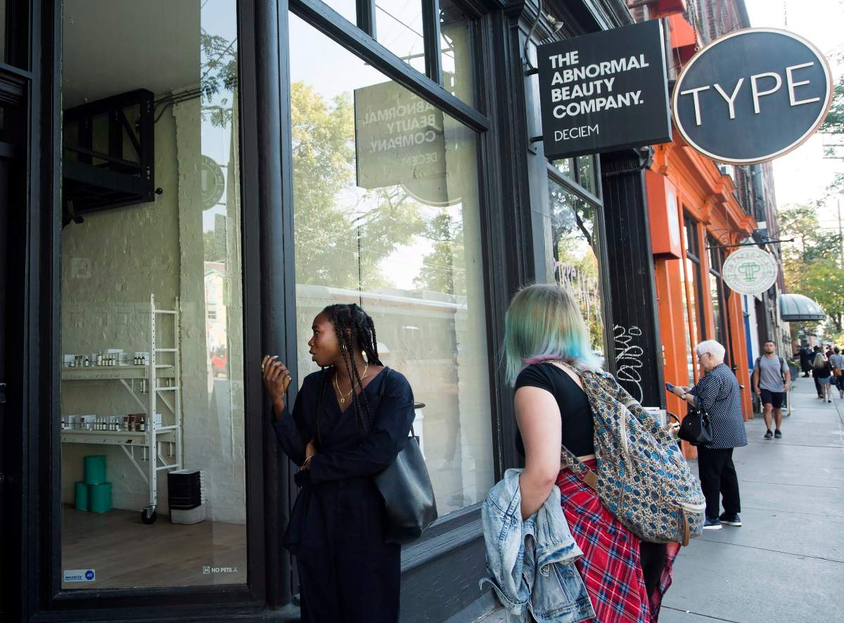 People react as they look outside the beauty supply store Deciem as it has closed all locations unexpectedly in Toronto on Tuesday, October 9, 2018. 