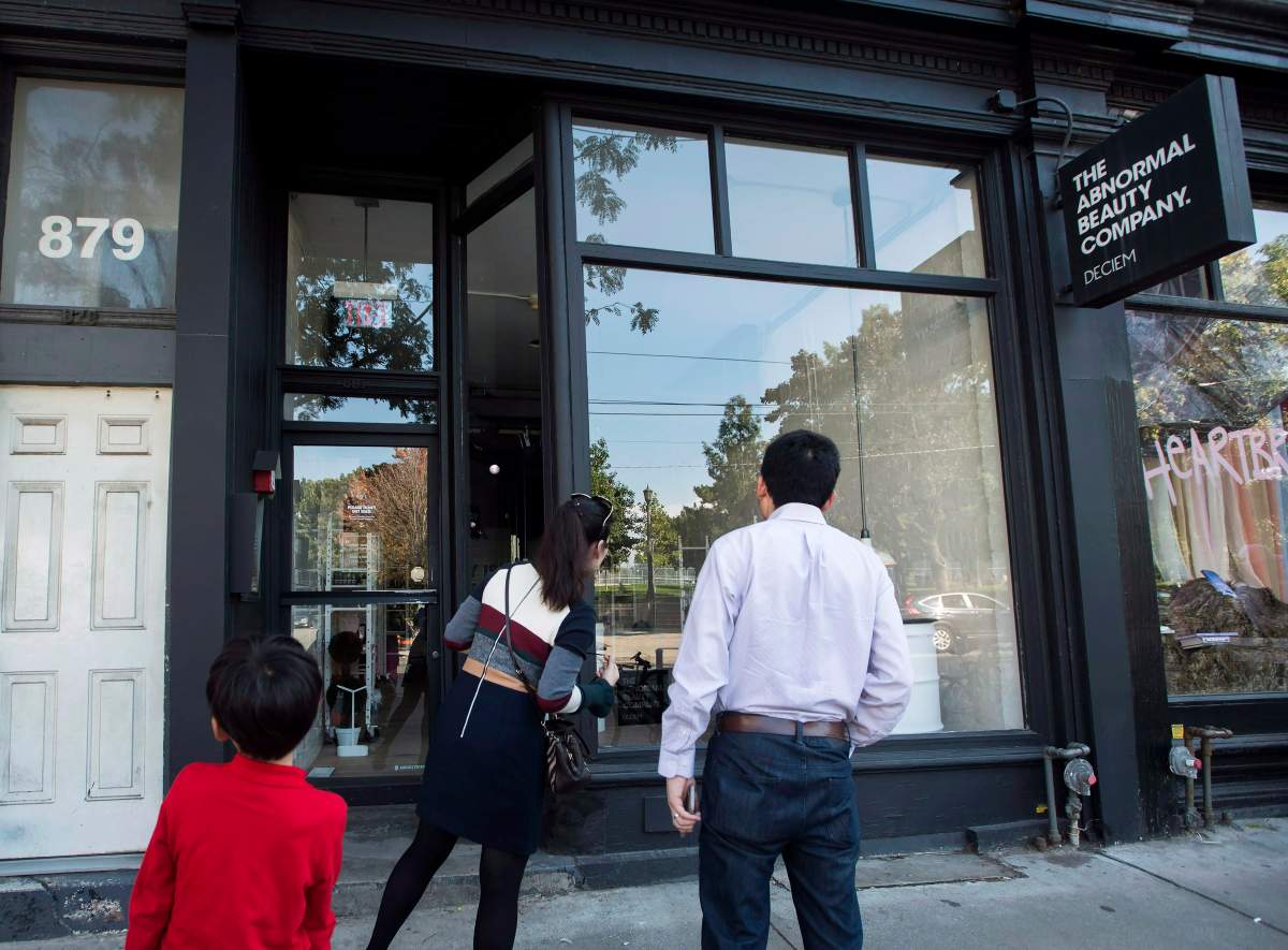 People react as they look outside the beauty supply store Deciem as it has closed all locations unexpectedly in Toronto on Tuesday, October 9, 2018. 