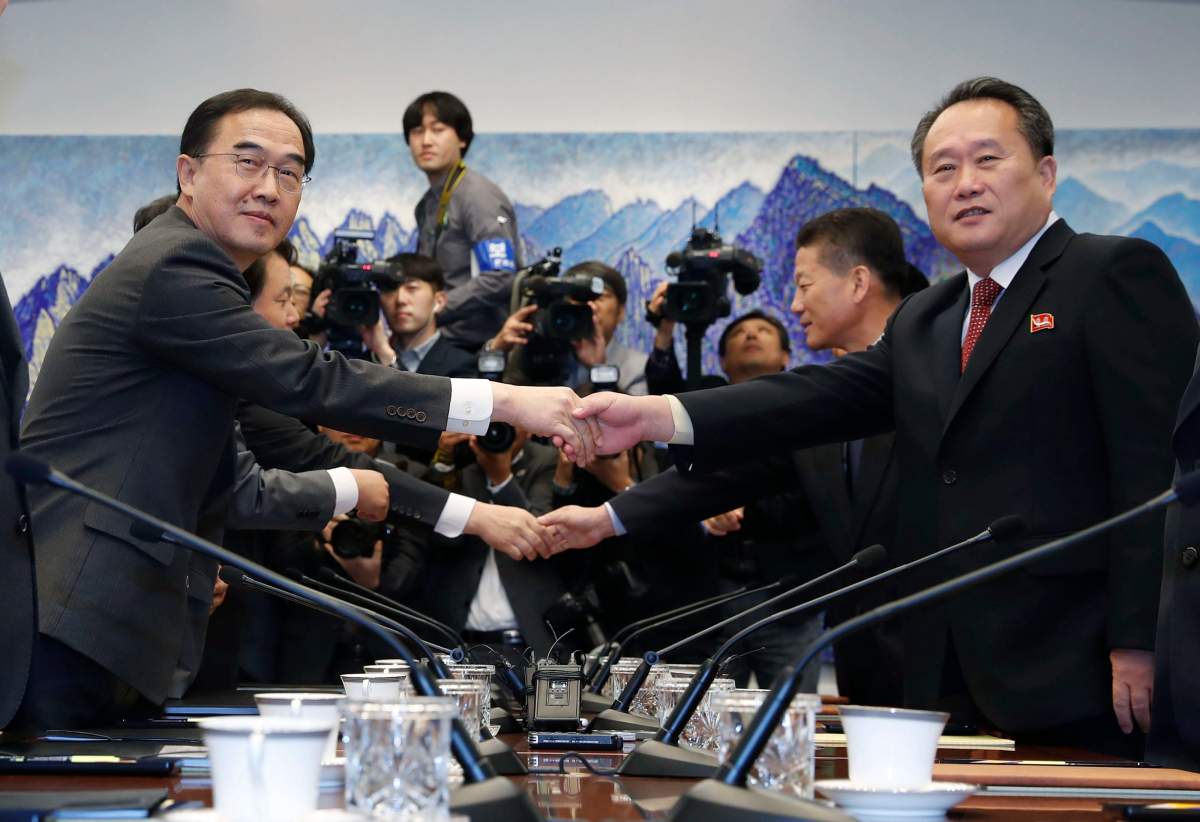 South Korean Unification Minister Cho Myoung-gyon (L) shakes hands with his North Korean counterpart Ri Son-gwon at the truce village of Panmunjom, 15 October 2018.