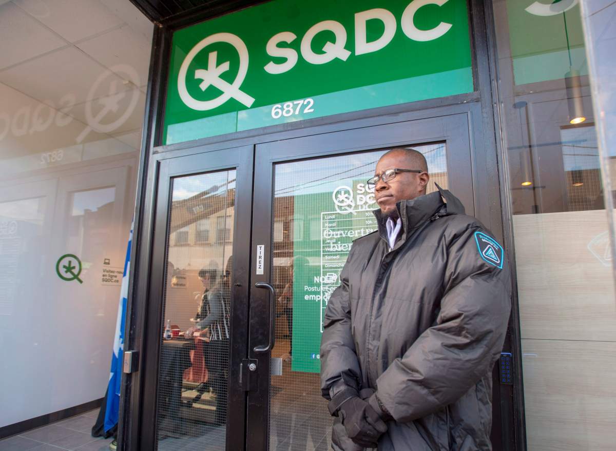 A security guard stands in front of a new Societe Quebecoise du Cannabis (SQDC) store before a media preview Tuesday, October 16, 2018 in Montreal. The legal sale of cannabis begins in Canada on Wednesday, Oct. 17, 2018.