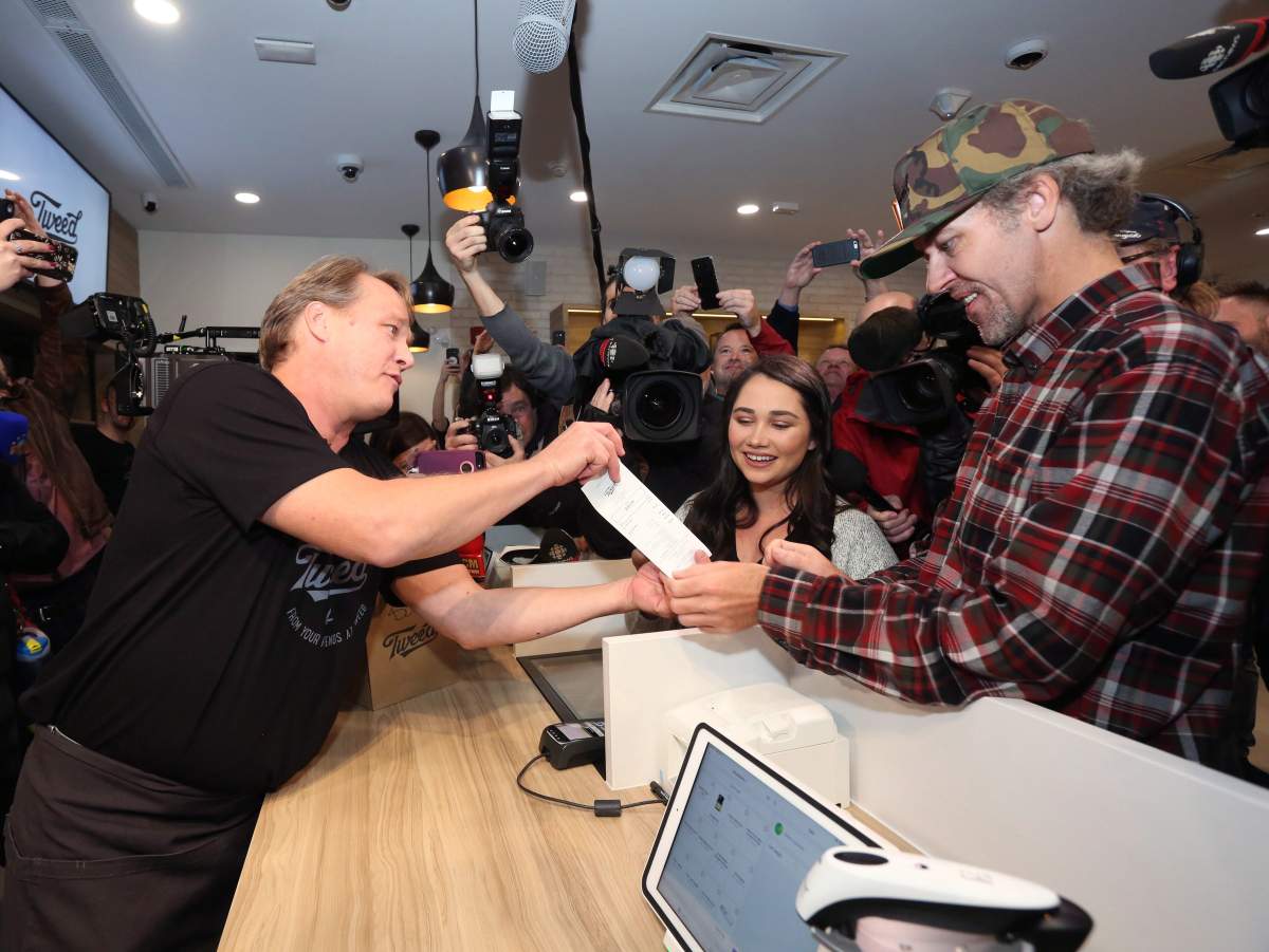 Canopy Growth CEO Bruce Linton, left to right, provides the receipt for the first legal cannabis for recreation use sold in Canada to Nikki Rose and Ian Power at the Tweed shop on Water Street in St. John’s N.L. at 12:01 am NDT on Wednesday October 17, 2018.