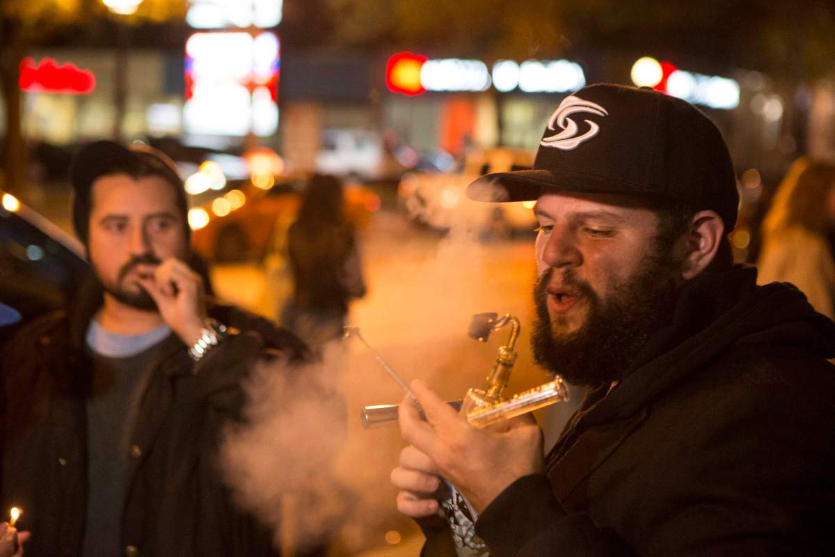 People smoke Cannabis on the street in Toronto on Wednesday October 17, 2018. Midnight signalled the legalization of Cannabis across Canada.