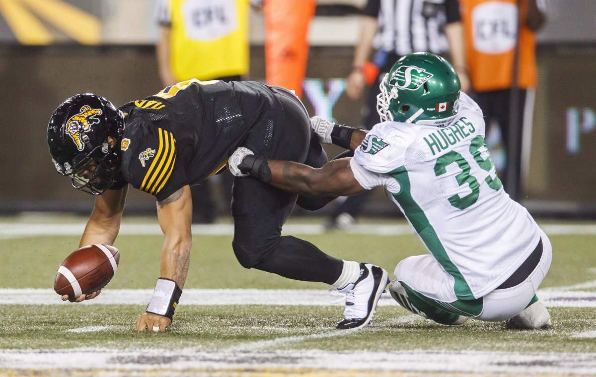 Saskatchewan Roughriders' Charleston Hughes sacks Hamilton Tiger-Cats quarterback Jeremiah Masoli during second half CFL football action in Hamilton, Ont., on July 19, 2018. 