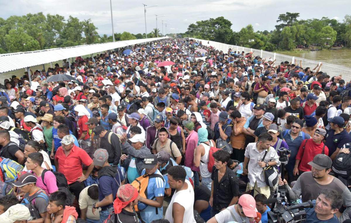 Thousands of Honduran migrants wait for access on the bridge that crosses the Suchiate River after crossing the fence on the border with Guatemala to enter in Ciudad Hidalgo, Mexico.