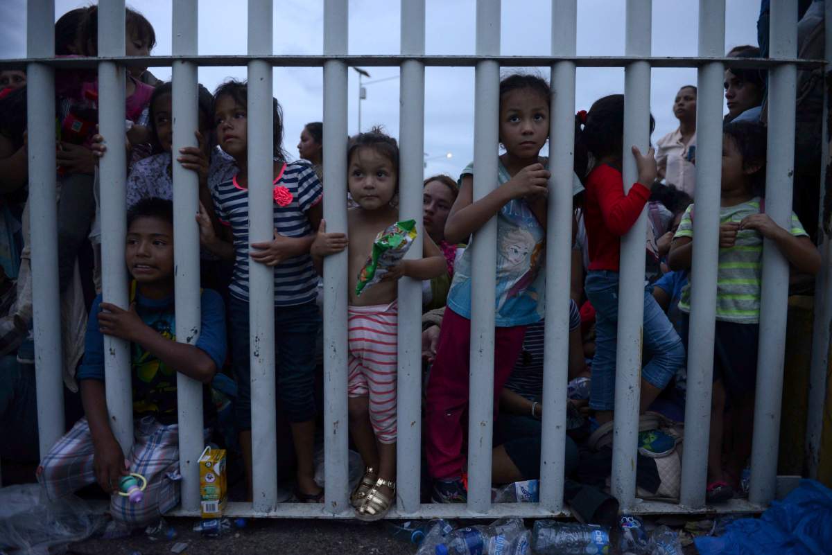 Migrant children bound for the U.S.-Mexico border wait on a bridge that stretches over the Suchiate River.