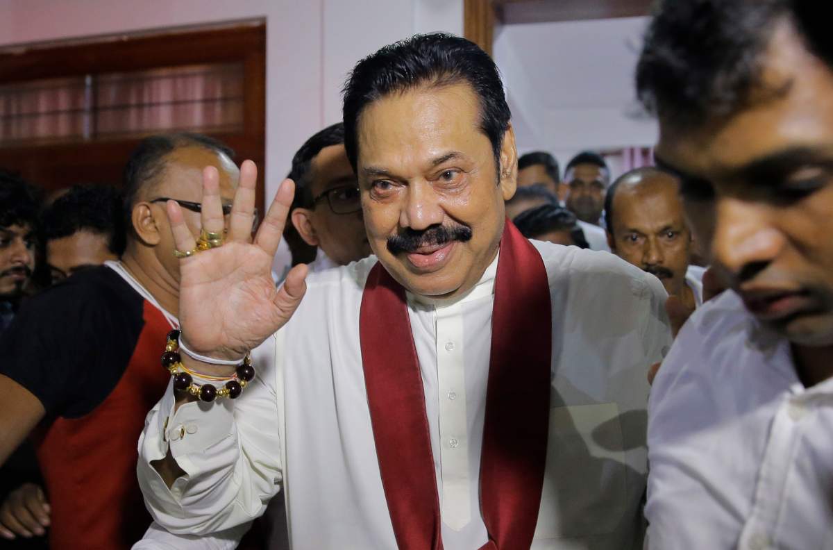 Newly appointed Sri Lankan Prime Minister Mahinda Rajapaksa, center, leaves a Buddhist temple after meeting his supporters in Colombo, Sri Lanka, Friday, Oct. 26, 2018.