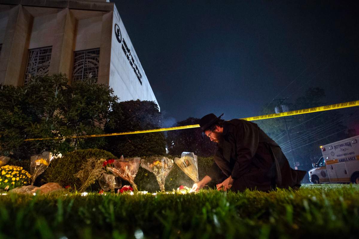 In this Oct. 27, 2018 photo, Rabbi Eli Wilansky lights a candle after a mass shooting at Tree of Life Synagogue in Pittsburgh’s Squirrel Hill neighborhood.
