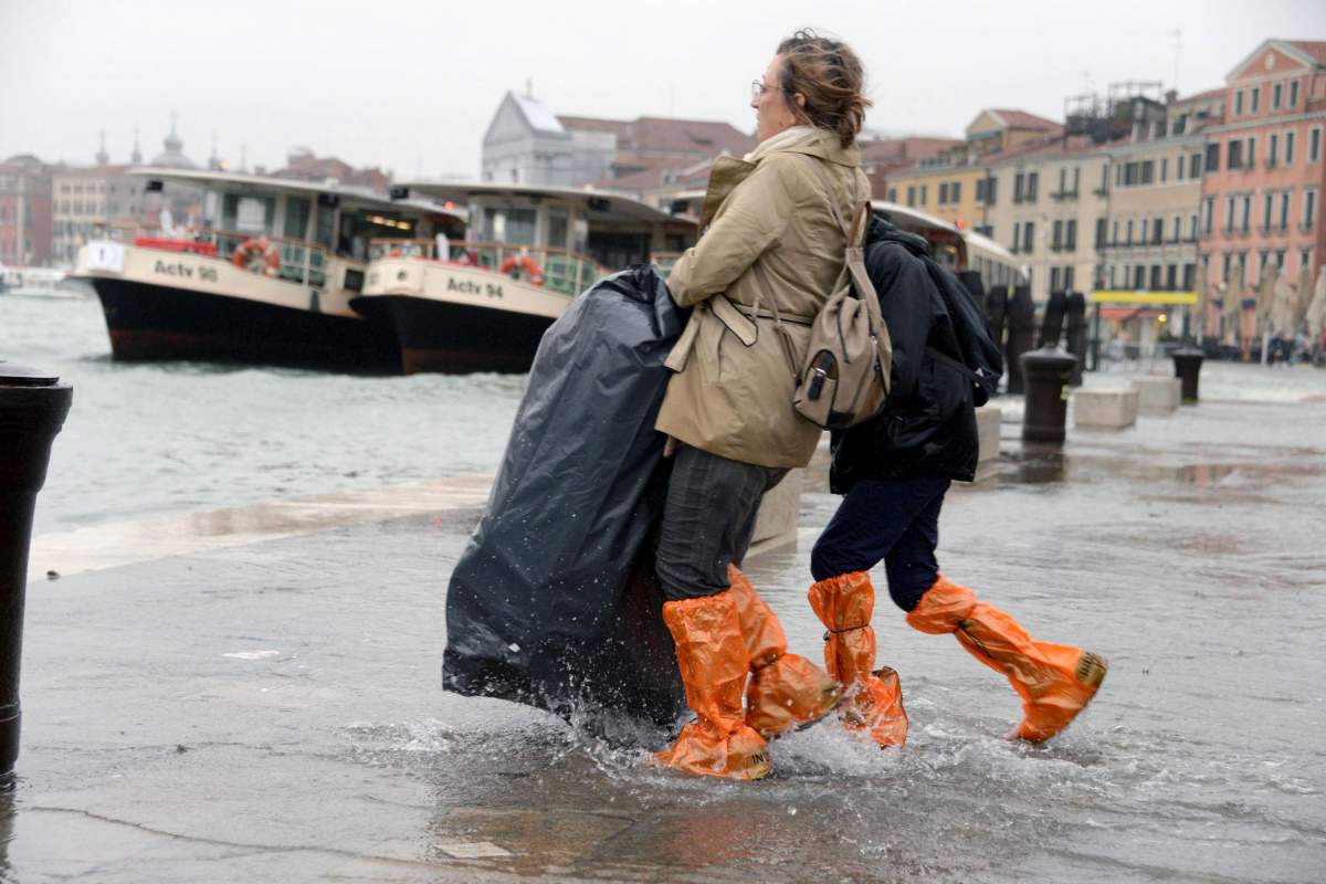 Tourists wander in high water in Venice, northern Italy, 29 October 2018
