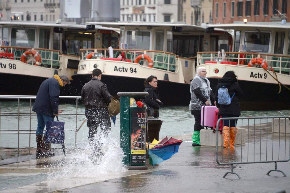 Tourists wander in high water in Venice, northern Italy, 29 October 2018.