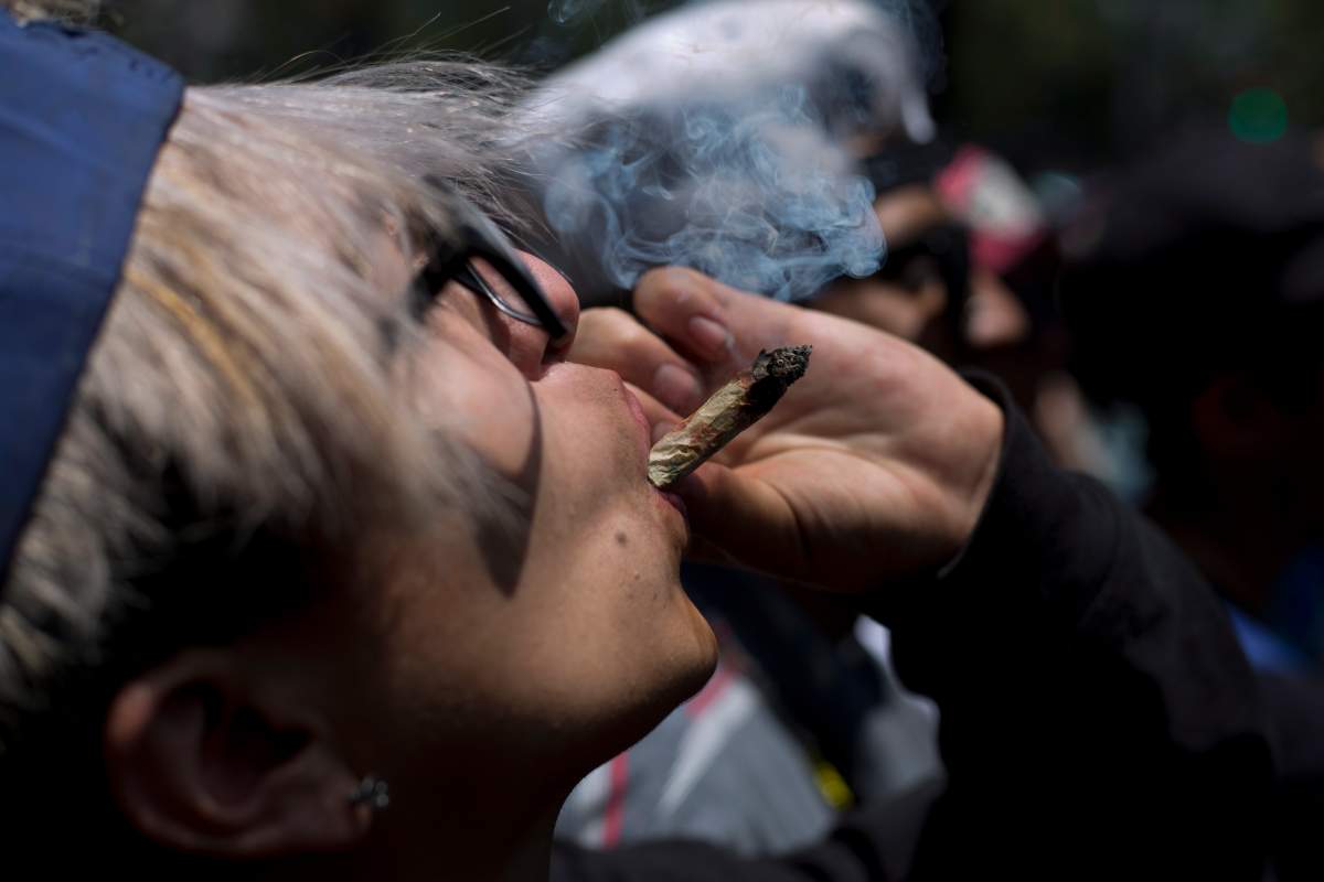 FILE - In this April 20, 2018 file photo,  a young man smokes marijuana to celebrate the International Day for Cannabis in Mexico City.