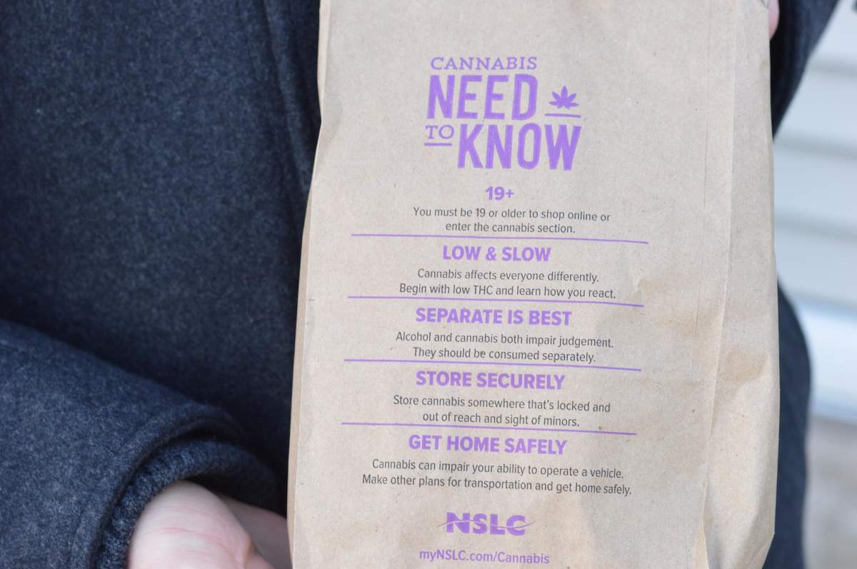 Daniel Moore holds a brown bag that the NSLC provides to all of its customers who purchase cannabis products. Taken in Halifax on Oct. 17, 2018.