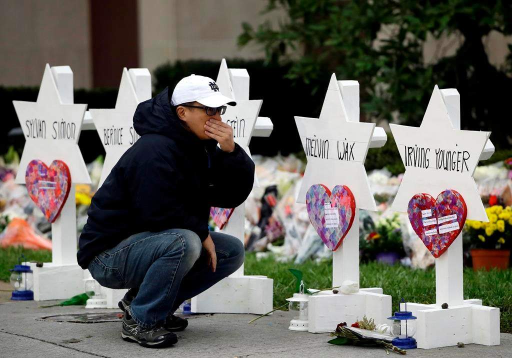 A person pauses in front of Stars of David with the names of those killed in a deadly shooting at the Tree of Life Synagogue, in Pittsburgh, Monday, Oct. 29, 2018.