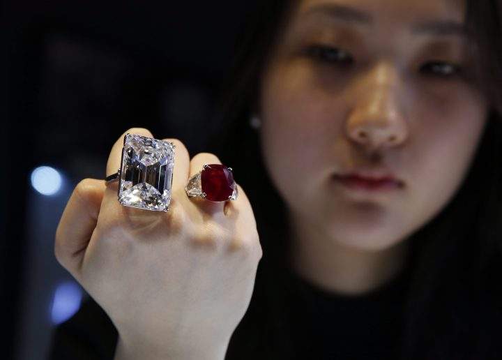 A model displays a 100.20-carat diamond, left, and a 25.59-carat Burmese ruby, known as the Sunrise Ruby, during a media preview for the Sotheby’s auction in Hong Kong Friday, April 3, 2015.