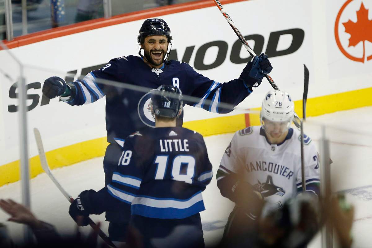 Winnipeg Jets' Dustin Byfuglien (33) and Bryan Little (18) celebrate Byfuglien's goal against the Vancouver Canucks during third period NHL action in Winnipeg on Thursday, October 18, 2018. 