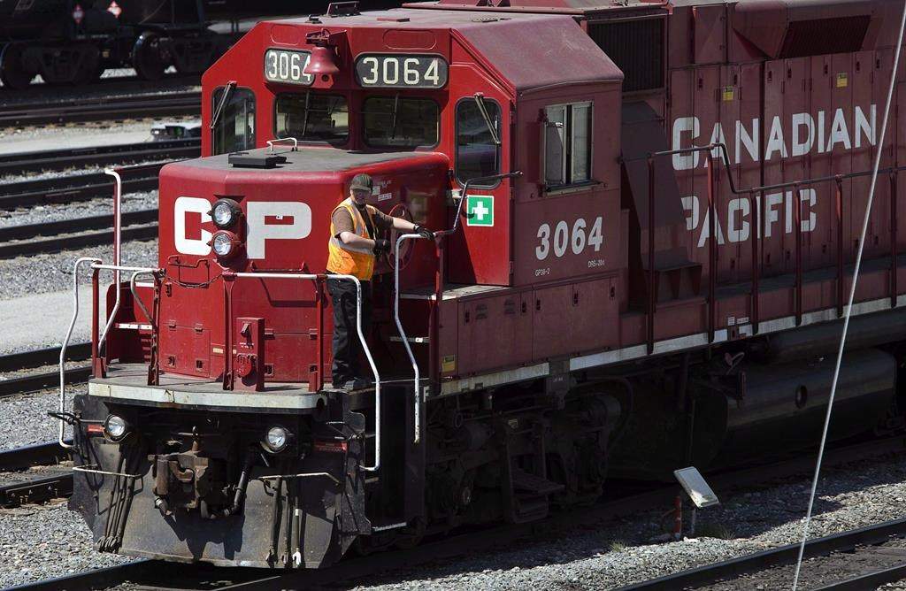 File: A Canadian Pacific Railway employee walks along the side of a locomotive in a marshalling yard in Calgary, Wednesday, May 16, 2012.