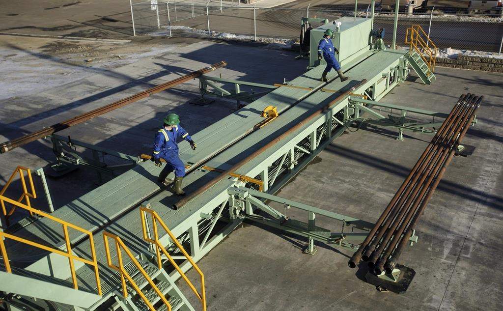 Trainees roll pipe off the catwalk during a training session to lay down drill pipe on a rig floor at Precision Drilling in Nisku, Alta., on Friday, January 20, 2016.