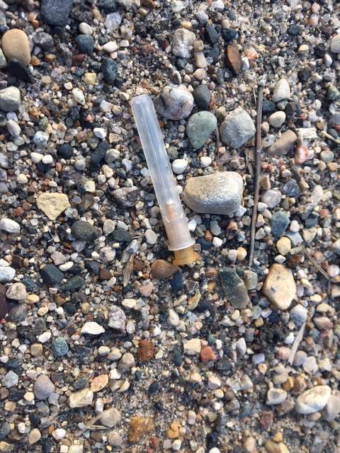 A discarded needle lies on the ground outside a building near Rosser Avenue in Brandon.