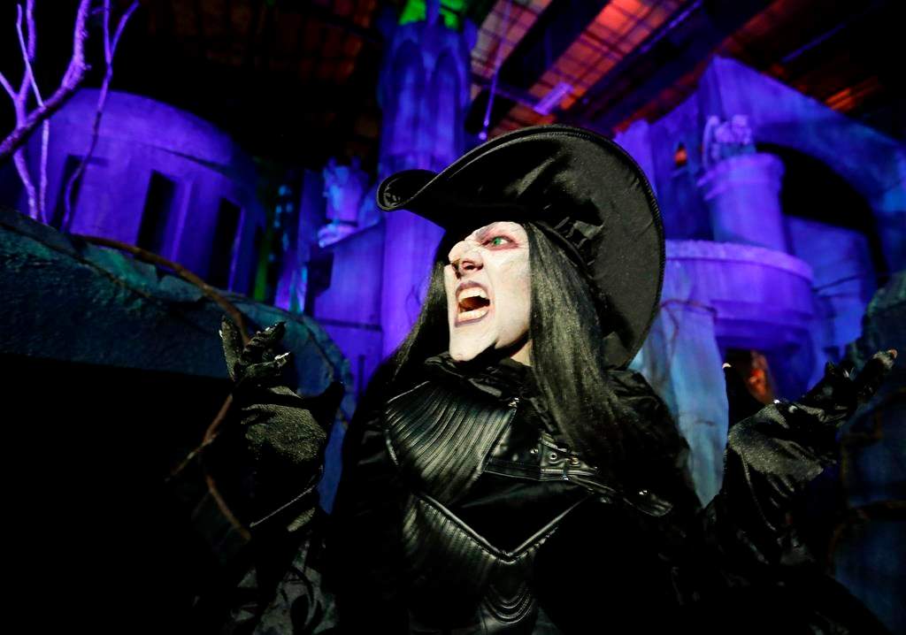 In this Wednesday, Sept. 12, 2018 photo, Laura Law performs as a witch at the Scary Tales haunted house at Halloween Horror nights at Universal Studios in Orlando, Fla.
