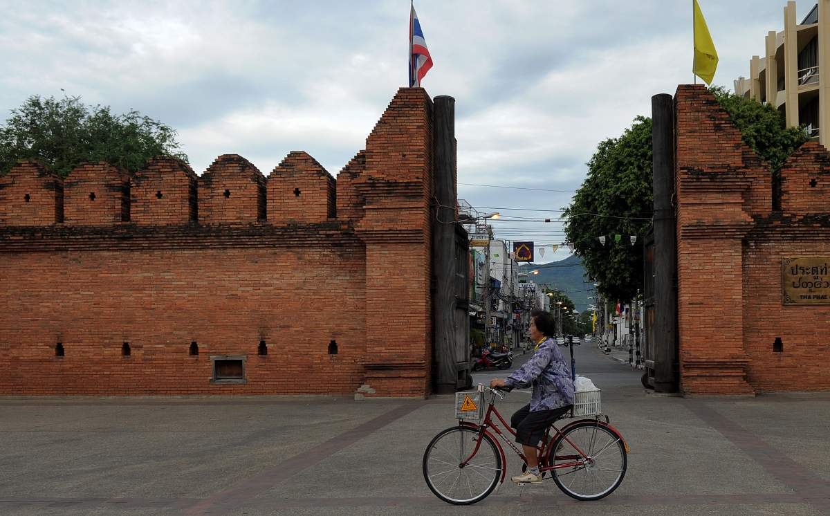 A Thai woman rides her bicycle past the Tha Phae gate in Chiang Mai, some 700kms from Bangkok on May 23, 2010.