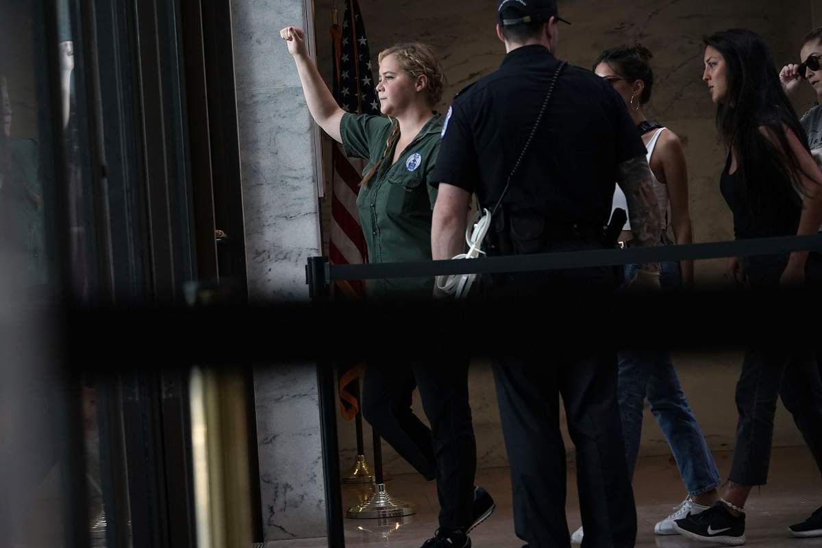 Comedian Amy Schumer (L) is led away after she was arrested during a protest against the confirmation of Supreme Court nominee Judge Brett Kavanaugh October 4, 2018 at the Hart Senate Office Building on Capitol Hill in Washington, DC. (Photo by Alex Wong/Getty Images)