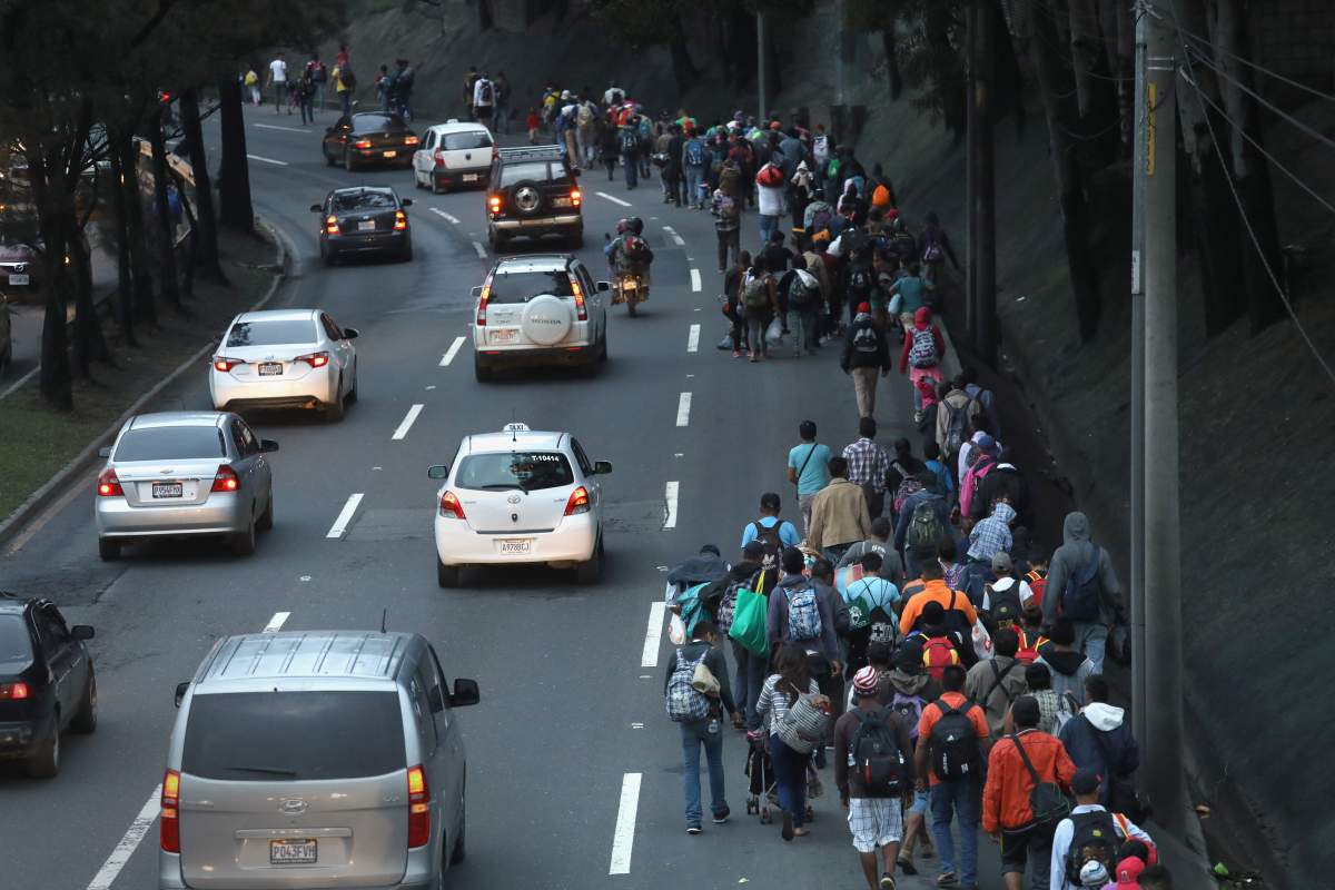 A caravan of immigrants departs the Guatemalan capital city at dawn en route to the Mexican border on October 18, 2018, in Guatemala City, Guatemala.