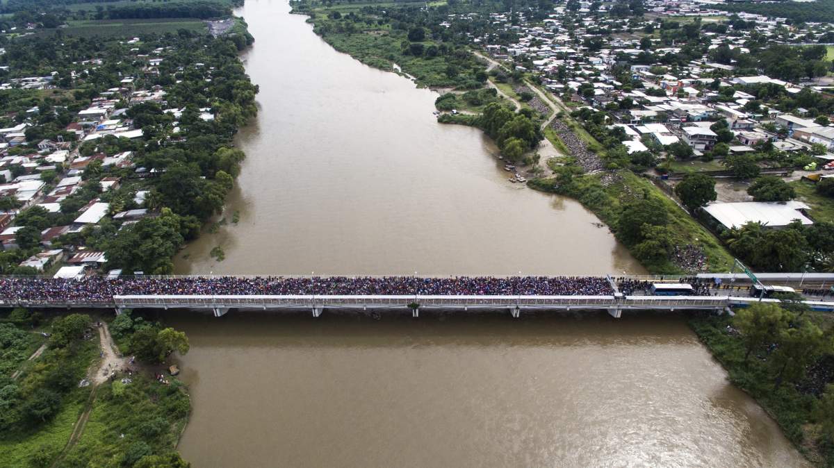 Aerial view of a Honduran migrant caravan heading to the U.S., as it is stopped at a border barrier on the Guatemala-Mexico international bridge in Ciudad Hidalgo, Chiapas state, Mexico, on October 19, 2018.