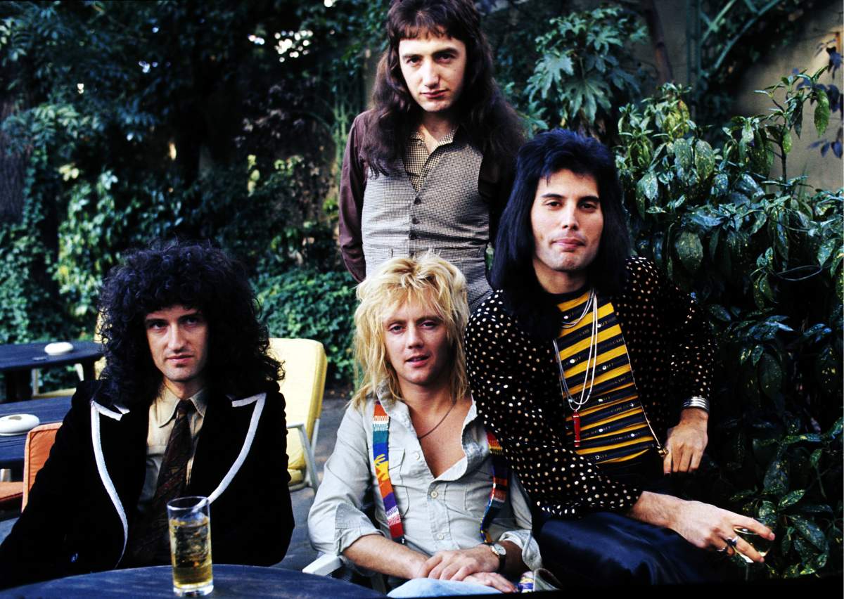 (L-R) Brian May, John Deacon (standing), Roger Taylor and Freddie Mercury of Queen at Les Ambassadeurs on Sept. 8, 1976 in London, England.
