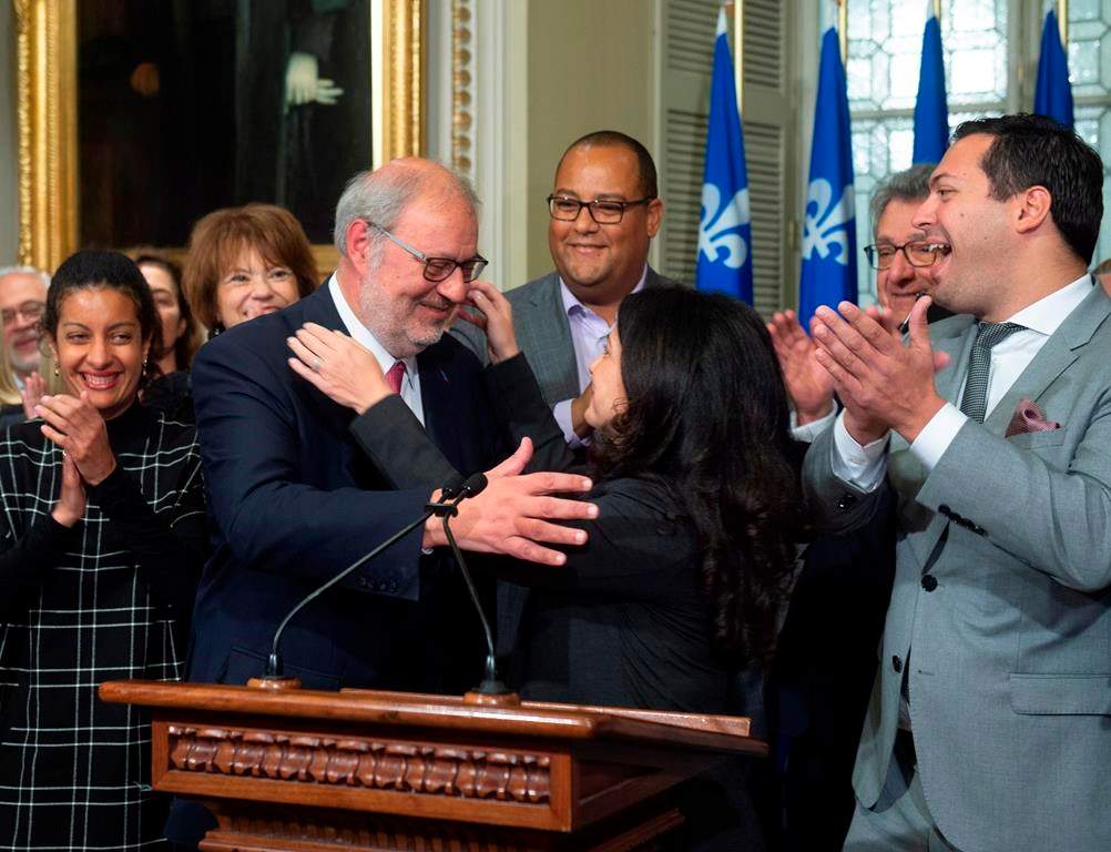 Interim Quebec Liberal opposition leader Pierre Arcand, centre left, is congratulated by Liberal caucus president Filomena Rotiroti, centre right, while caucus members applaud, on Friday, Oct. 5, 2018 at the legislature in Quebec City.
