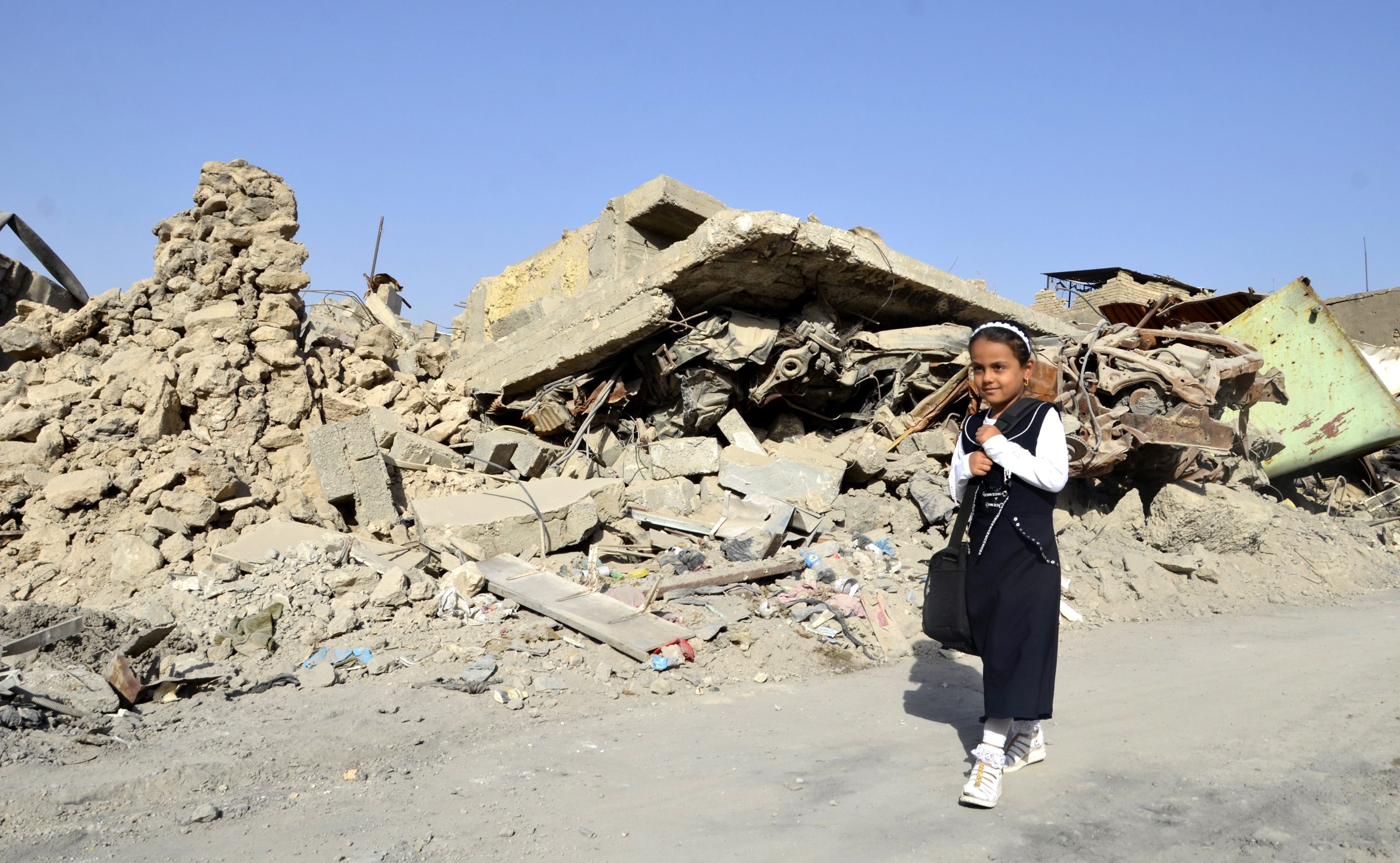 An Iraqi student walks amid the the rubble of houses on their way to school at the old city, western Mosul, northern Iraq, in September 2018. EPA/AMMAR SALIH