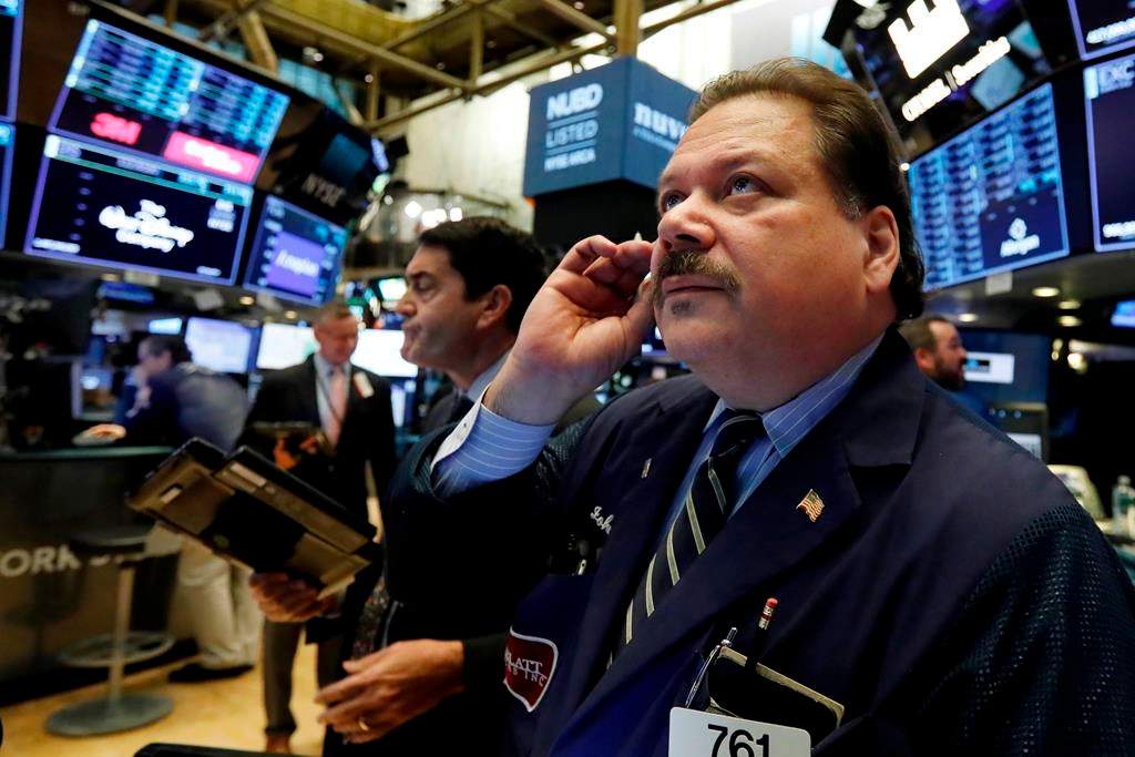 FILE- In this Oct. 15, 2018, photo trader John Santiago, right, works on the floor of the New York Stock Exchange. The U.S. stock market opens at 9:30 a.m. EDT on Wednesday, Oct. 24.
