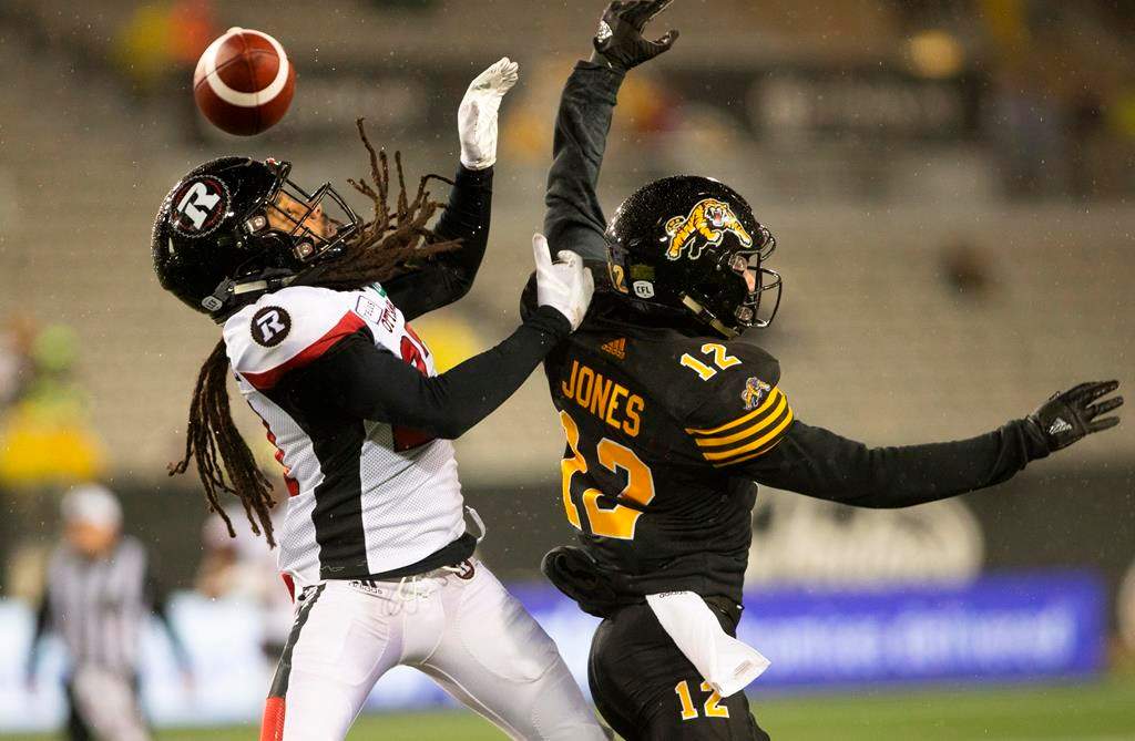 Hamilton Tiger-Cats wide receiver Mike Jones (12) can not get his hands on the ball while defended by Ottawa Redblacks Sherrod Baltimore during second half CFL Football game action in Hamilton, Ont. on Saturday, October 27, 2018. THE CANADIAN PRESS/Peter Power