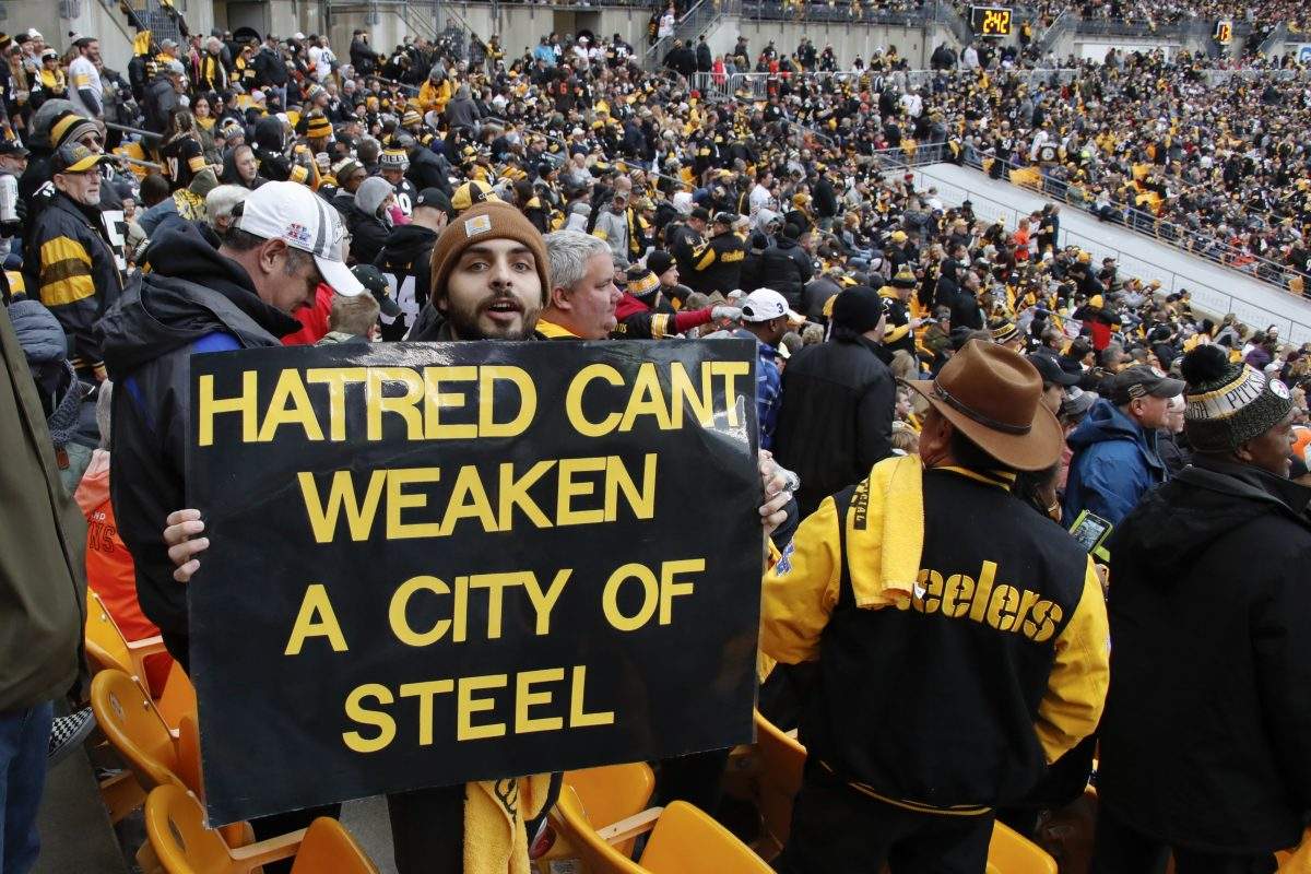 A Pittsburgh Steelers fan holds a sign honouring the victims of a deadly shooting spree at a synagogue on Saturday. (AP Photo/Gene J. Puskar)