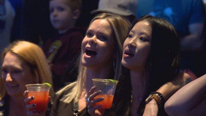 Event organizer Samantha Lee (right) sings along to “We Are The Champions” at Saturday’s concert.