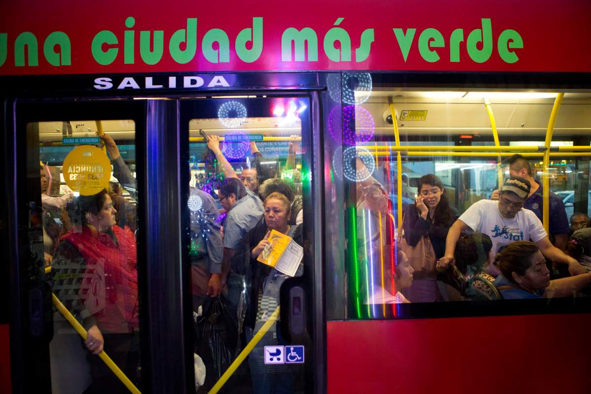 Commuters ride a “Metrobus” rapid transit bus as night falls in Mexico City, Friday, Dec. 2, 2016.