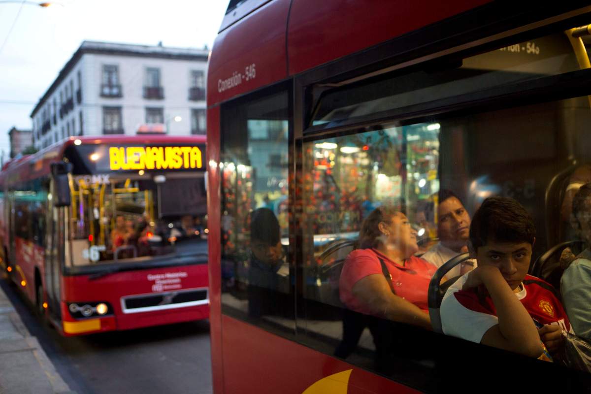 Commuters ride a "Metrobus" rapid transit bus as night falls in Mexico City, Friday, Dec. 2, 2016. 