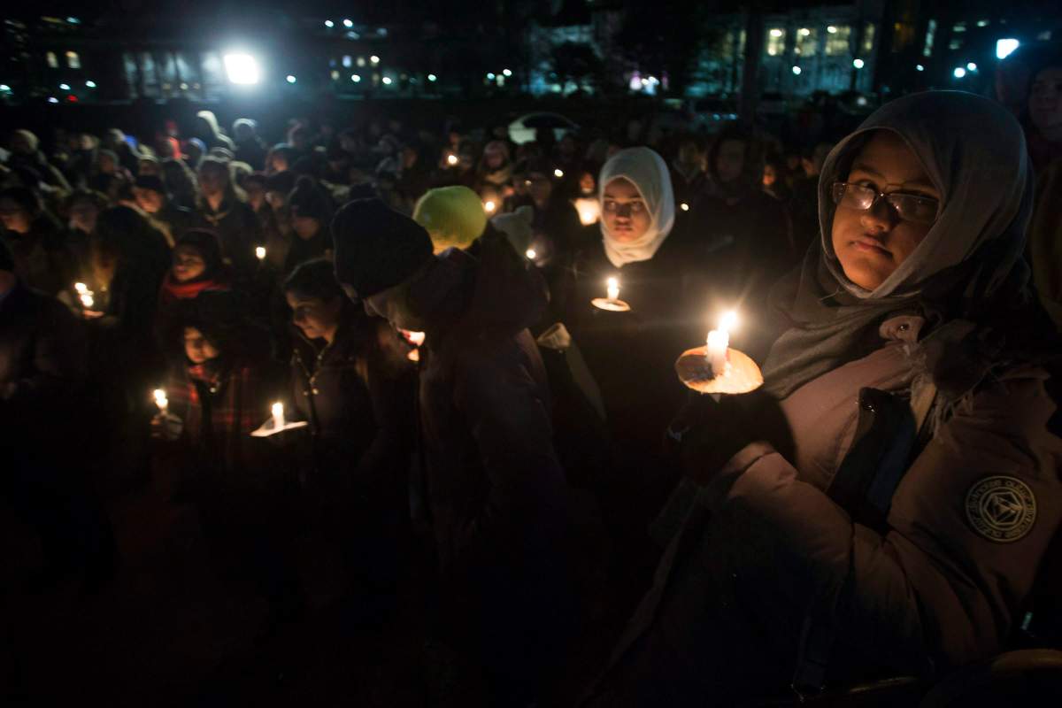 People gather to observe a candlelight vigil in Toronto, on Monday, January 30, 2017, for victims of the shooting at a Quebec City mosque.