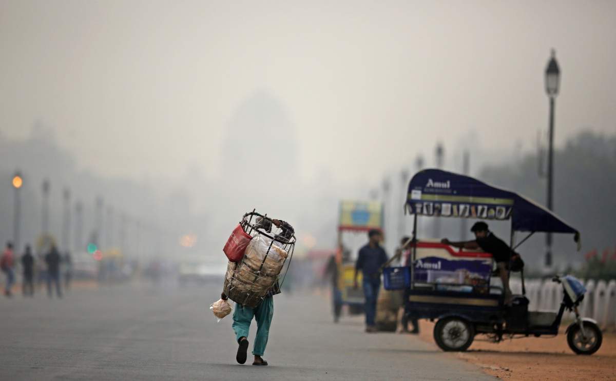 India’s Rashtrapati Bhawan, or the Presidential Palace is partly visible due to smog as a street vendor walks along Rajapth, the ceremonial boulevard in New Delhi, India, Thursday, Nov. 1, 2018.