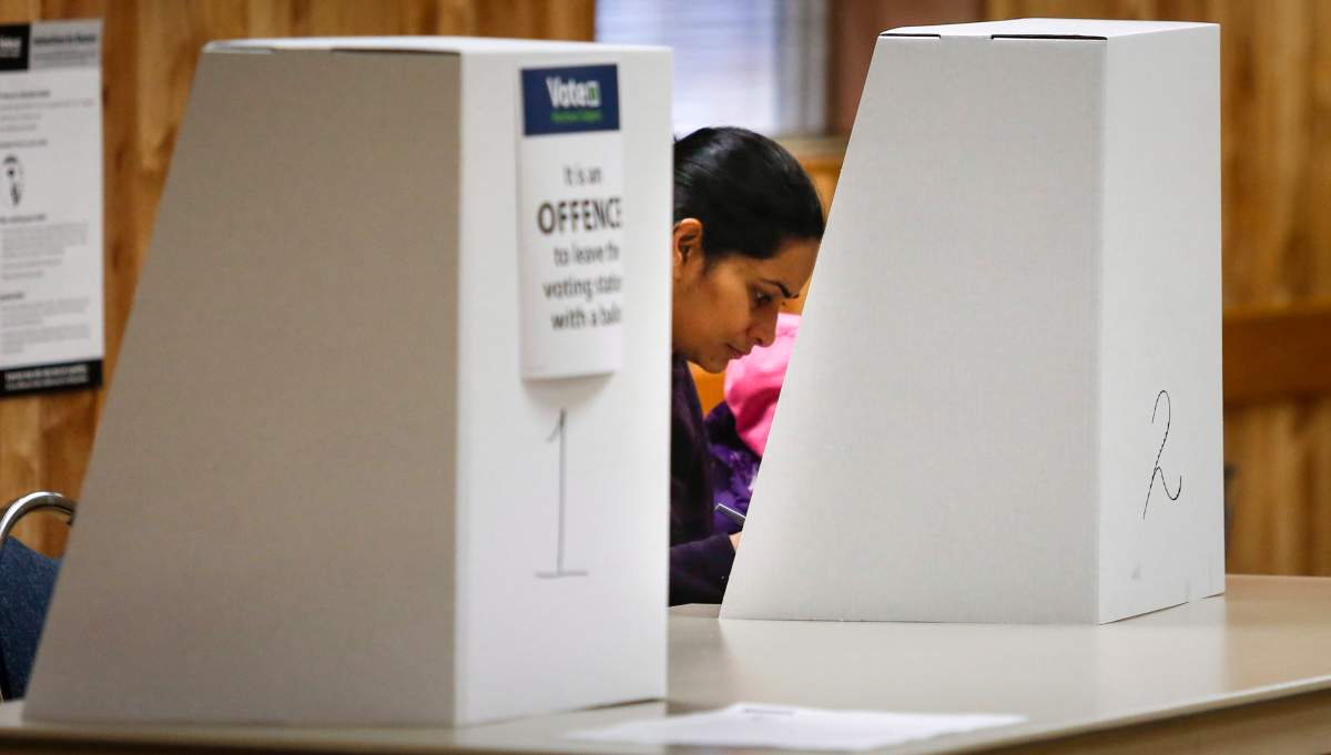 A Calgarian votes in a plebiscite on whether the city should proceed with a bid for the 2026 Winter Olympics, in Calgary, Alta., Tuesday, Nov. 13, 2018.
