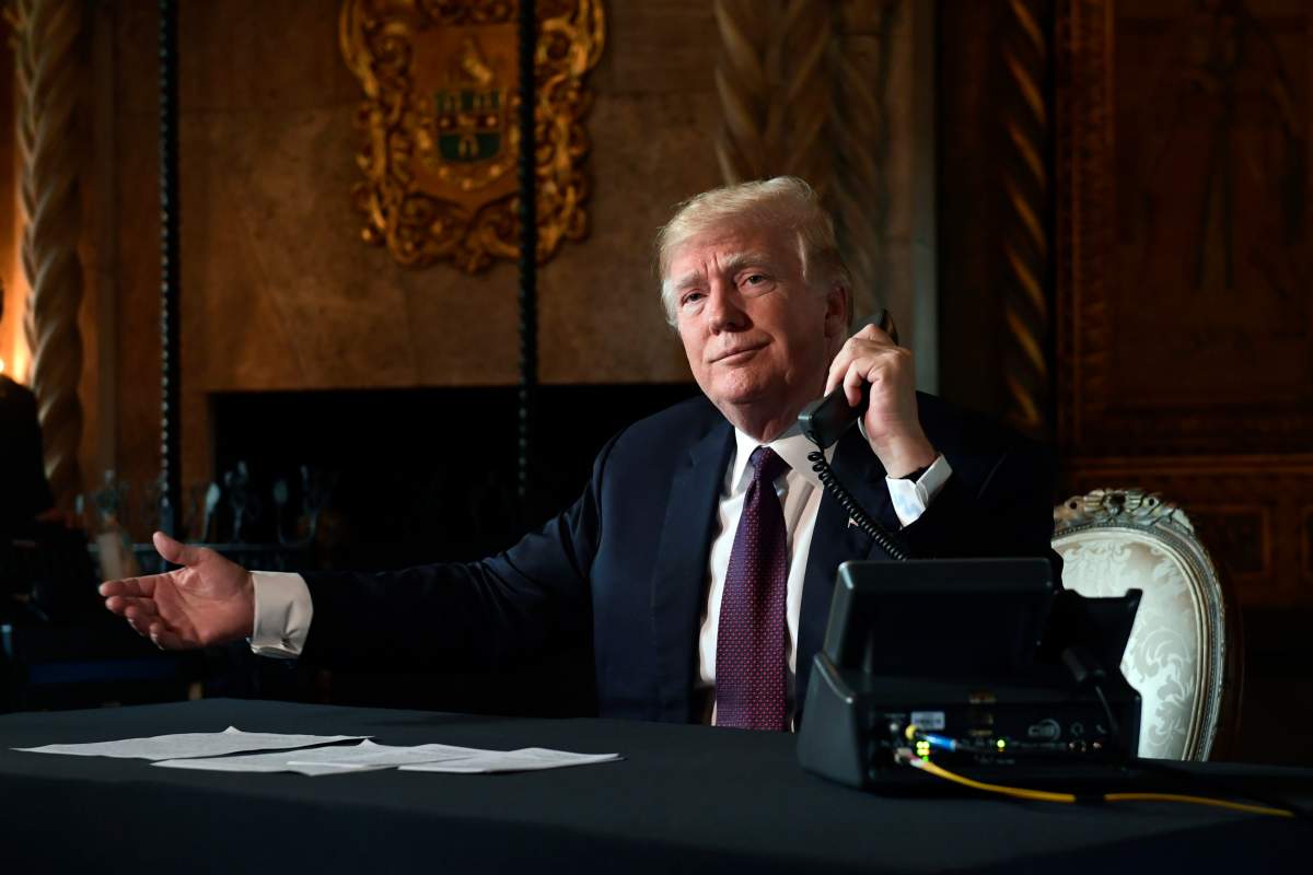 President Donald Trump asks if reporters can hear the audio as he talks with troops via teleconference from his Mar-a-Lago estate in Palm Beach, Fla., Thursday, Nov. 22, 2018.