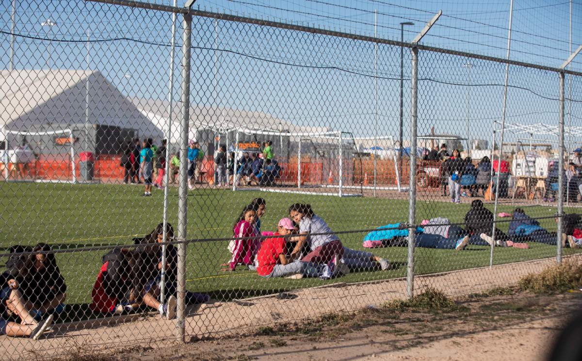 In this Nov. 25, 2018 photo provided by Ivan Pierre Aguirre, migrant teens held inside the Tornillo detention camp look at protestors waving at them outside the fences surrounding the facility in Tornillo, Texas.