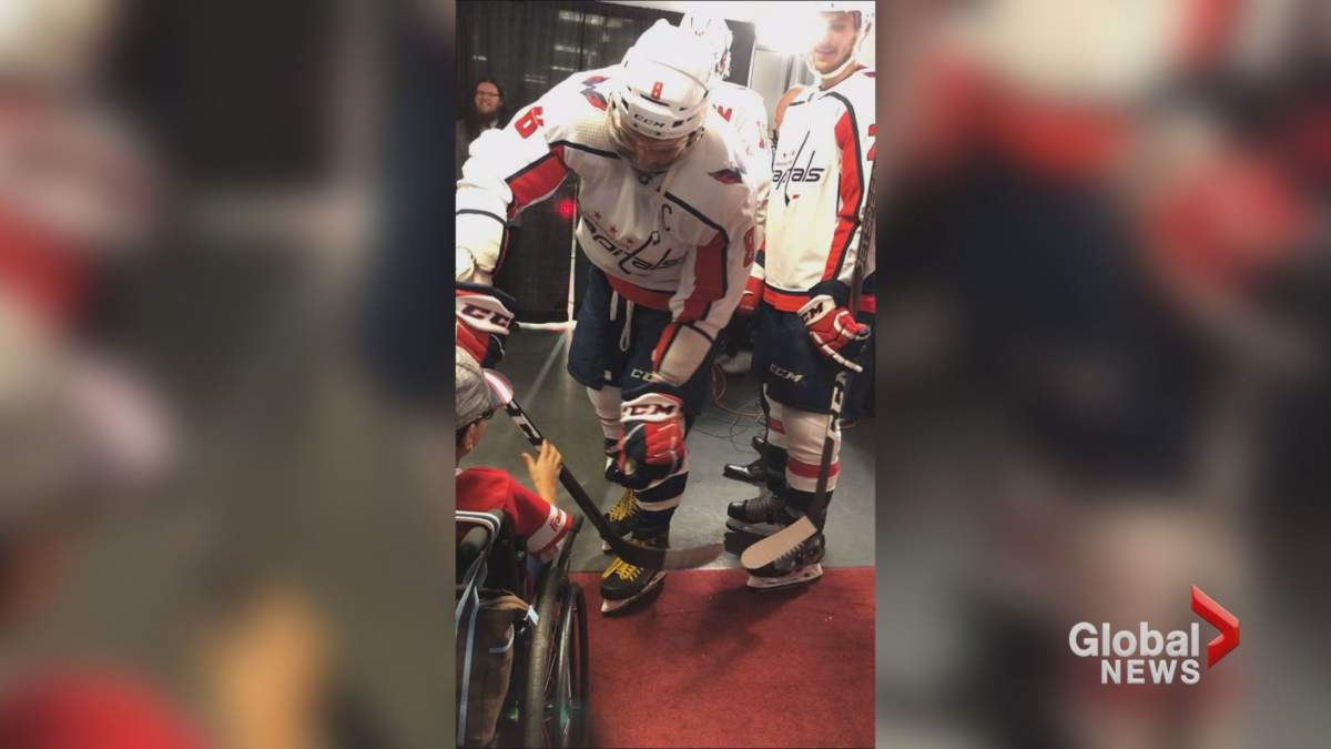 Washington Capitals captain Alexander Ovechkin gives his hockey stick to nine-year-old fan, Aydin Ali.