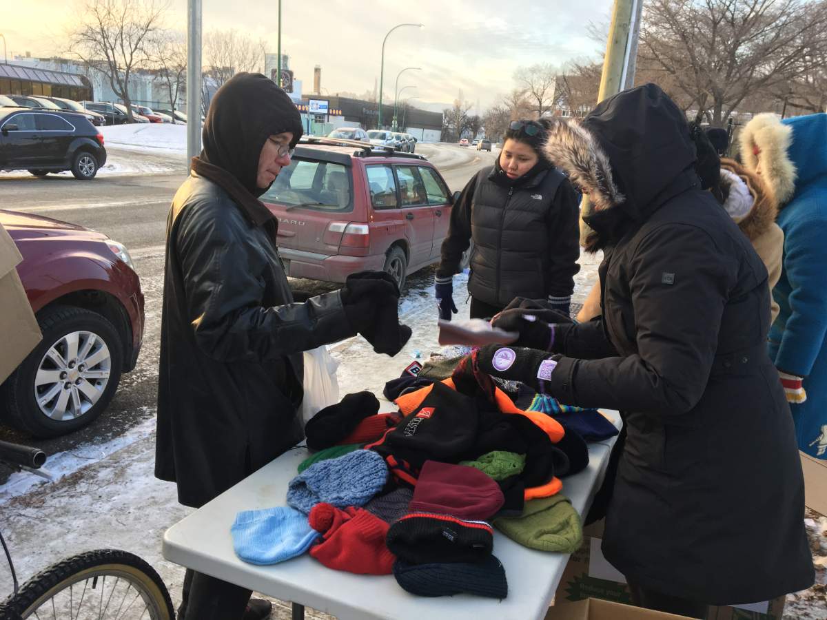 Bundled-up students handed out winter gear to those in need at the corner of Main Street and Dufferin Avenue on Sunday afternoon.