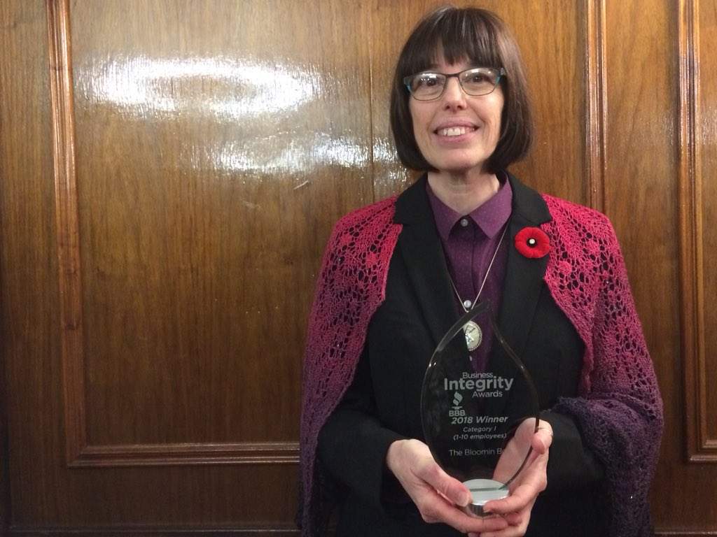 Isa Webb, CEO and manager of The Bloomin Bog, holds her Business Integrity Award from the Better Business Bureau.