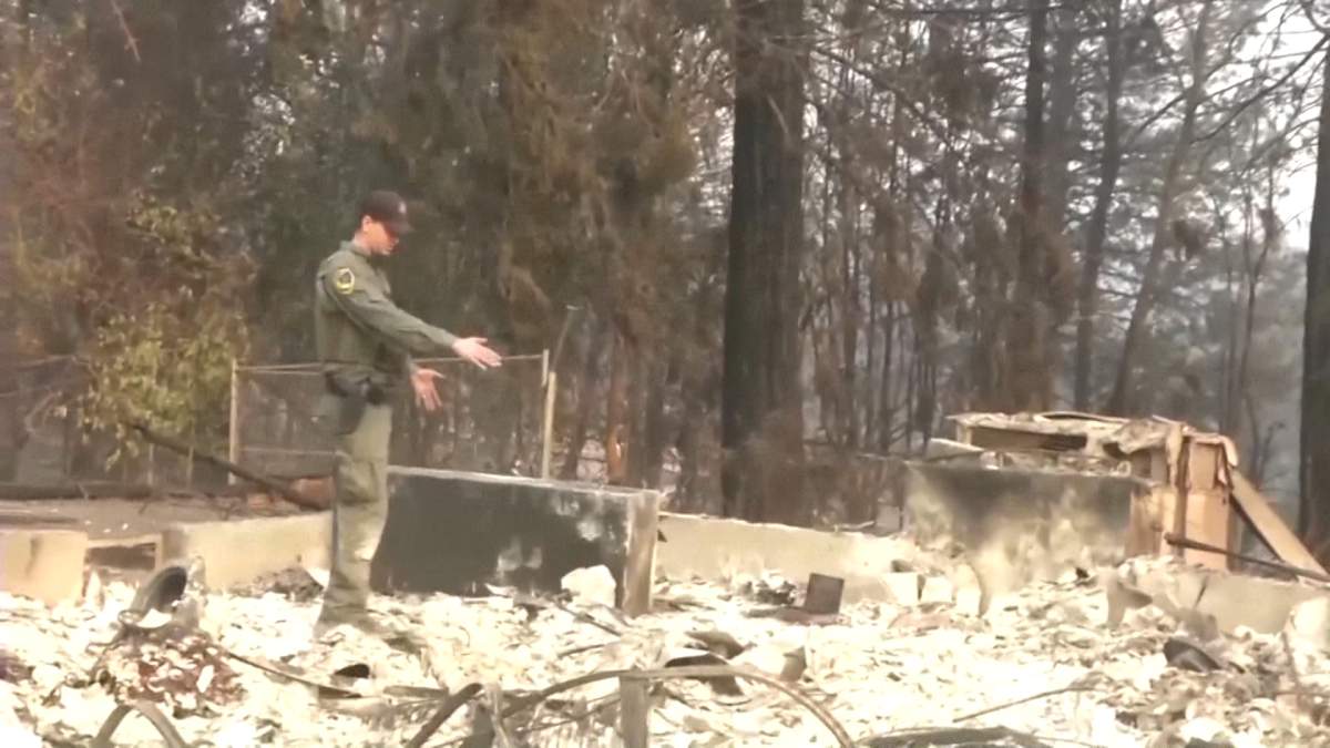 Jake Olsen shows where his wife’s wedding ring was found as he stood in the rubble of his California home on Saturday, Nov. 11, 2018.