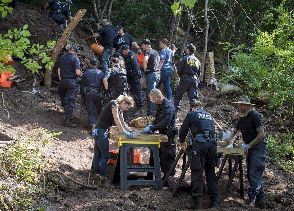 Members of the Toronto Police Service sift and excavate materials from the back of property along Mallory Cres. in Toronto after confirming they have found human remains during an investigation in relation to alleged serial killer Bruce McArthur on July 5, 2018.