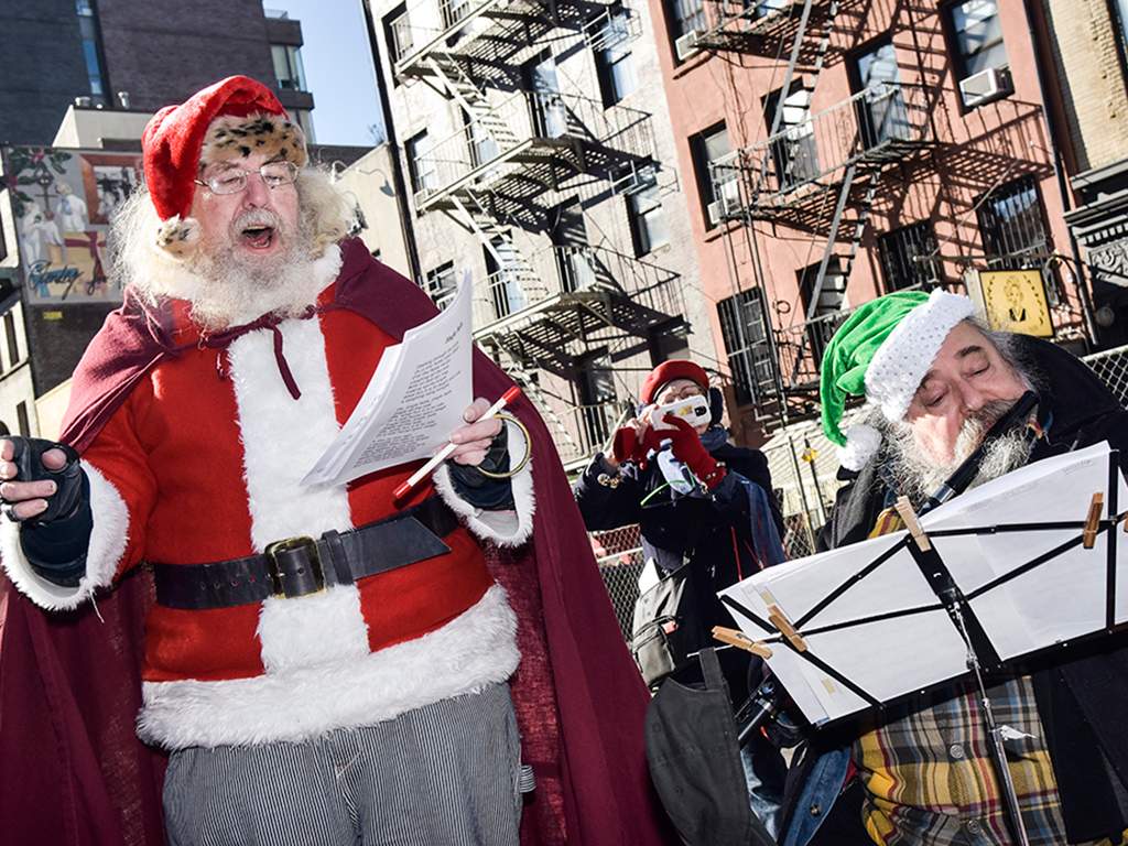 Andrew Bolotowsky  with Santa Claus and members of Earth is Our Mother sing Christmas carols at Petronsino Square on Dec. 21, 2017 in New York City. 