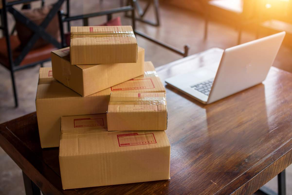 A pile of cardboard boxes next to a laptop