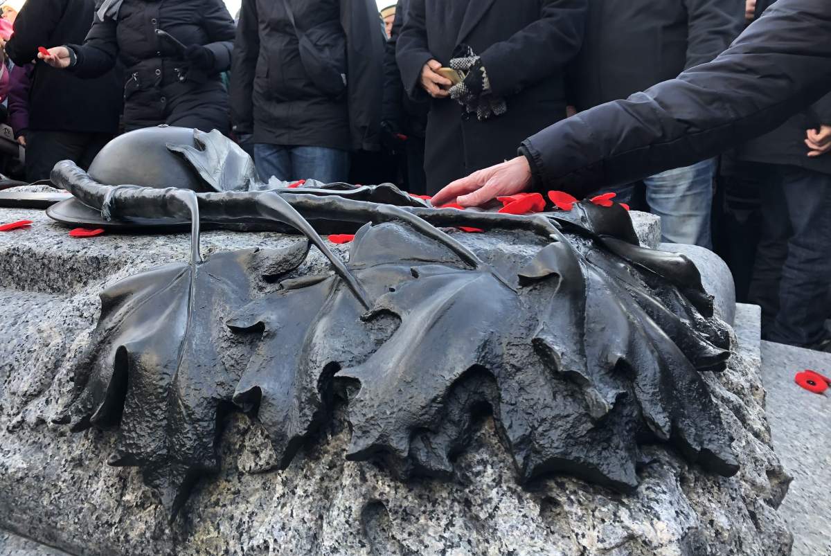 People lay their poppies on the Tomb of the Unknown Soldier at the base of the National War Memorial in Ottawa on Sunday, Nov. 11.