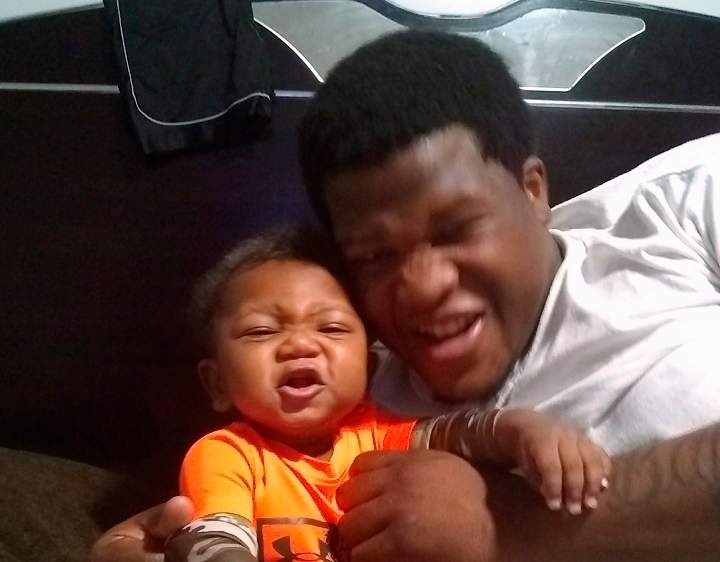 Jemel Roberson, A Chicago-area security guard who was shot by police while on the job, is seen with his infant son Tristan Roberson in this handout photo.