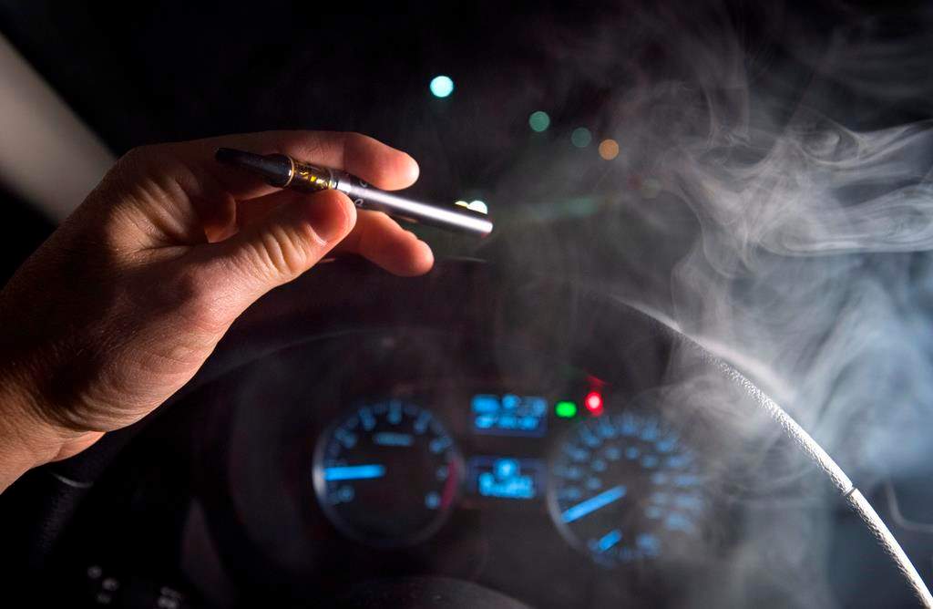 In this photo illustration, smoke from a cannabis oil vaporizer is seen as the driver is behind the wheel of a car in North Vancouver, B.C. Wednesday, Nov. 14, 2018.